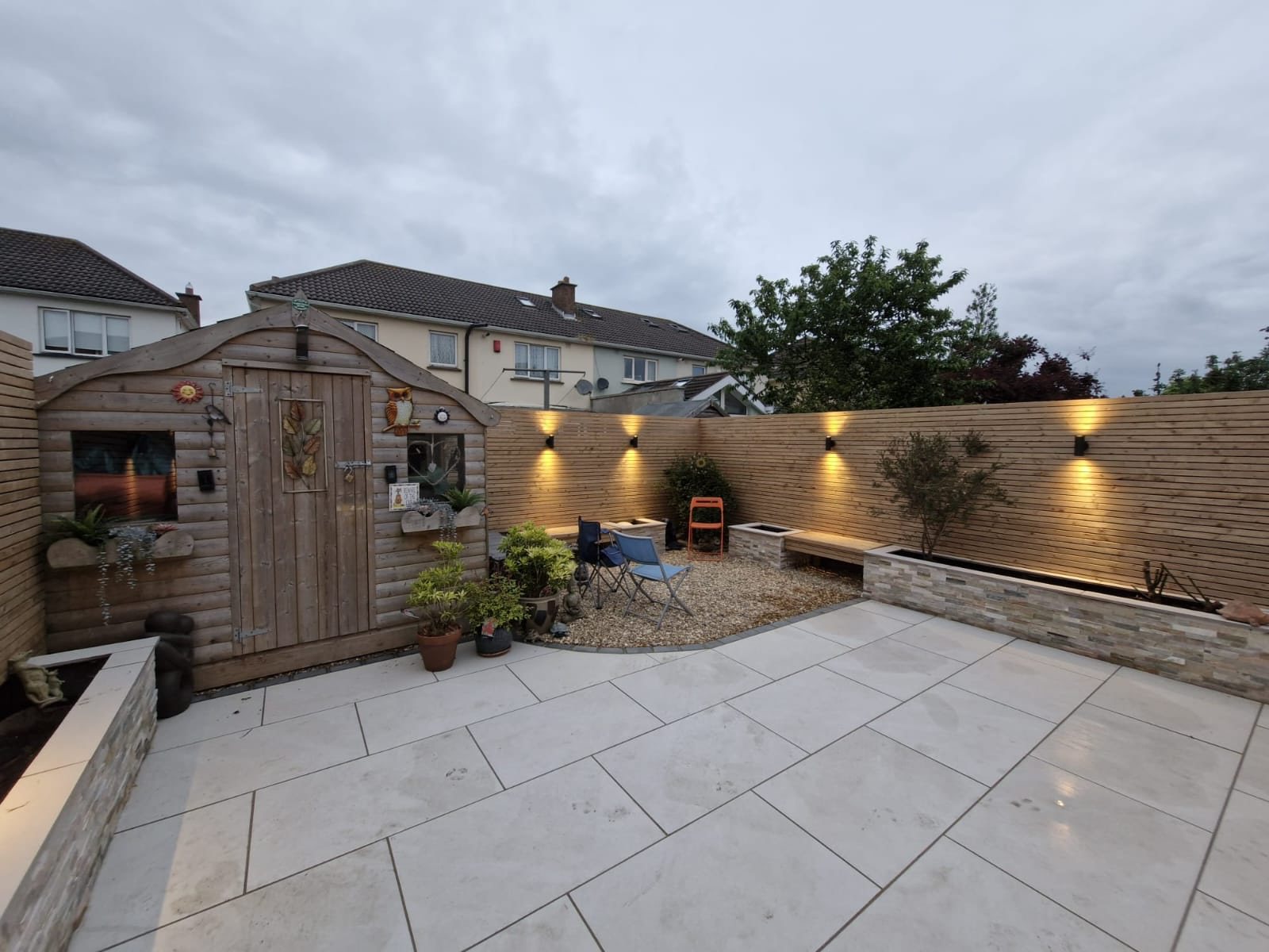 Evening patio with cedar slatted fencing and wall lights Dublin